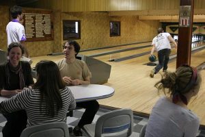 Hannah Yourd '09, Neil Finnegan '09 and Laura Simpson '09 shoot the breeze before they bowl next as Kennon Landis '09 throws a ball down down the lane. - Paul Kramer
