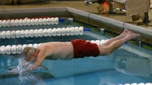 As a ceremonial gesture after winning the conference tournament on Sunday, President of the College, Russel K. Osgood, takes the first dive into the Obermiller Pool.  This is the final time Grinnell will host the MWC swimming and diving tournament. - Paul Kramer