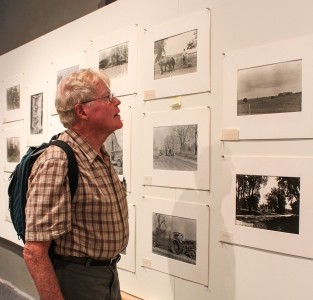 A visitor of Stewart Gallery examines the photos taken by Egbert Dunham. 