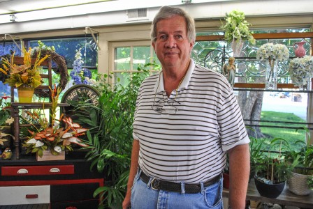 Jim White, owner of Bates Flowers, poses inside his flower store.