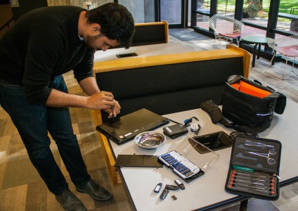 Shadman Asif uses a Hard Drive kit to fix a computer. Photo by Tela Ebersole