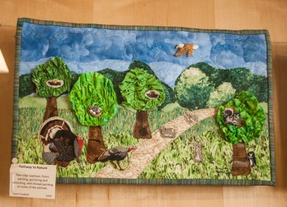 One of the quilts on display, “Pathway to Nature,” featuring turkeys, squirrels and trees. Photo by Sydney Steinle. 