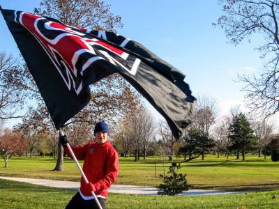 Stewart Bass ’18 raises the Grinnell flag at Midwest Conference Championships. Photo contributed. 