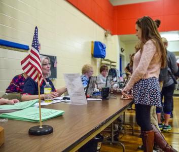 A volunteer assists a Grinnell student through the voting process in the Community Center on Election Day.  Photo by Leina'ala Voss.