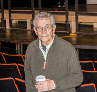 Professor Sandy Moffett poses for a photo in front of a stage. Professor, bluegrass performer and local government representative, Moffettt embodies all of the community. Photo by Sarah Ruiz.