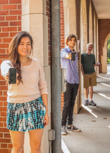 From left: Ruth Wu, Yazan Kittaneh and Alex French (all ‘17) show their smartphones while posing in the North Campus loggia. Photo by Rae Kuhlman