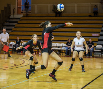 Margret Giles ’18  (center) in action versus Central College on Thursday, Sep. 17. while Olivia Fromm ’17 (left) and Sydney Vrecenar ’18 (right) look on.  Photo by John Brady