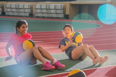 Runners Vedika Haralalka ’18 and Yufei Wang ’18 working out their cores at practice this week.  Photo by Sno Zhao