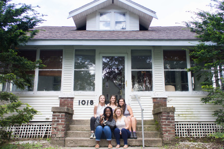 The residents, six human and one  reptilian, of 1018 East St. enjoy the spring sun on their porch. Photo by Sarah Ruiz.