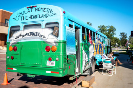 The bus for "A Home in the Heartland: Forgotten Stories of how Iowa Got to Be 'Us'" is painted differently than the four exhibits TRACES has run previously. The organization has driven Iowa's social history around the Midwest. Photo by Xiaoxuan Yang. 