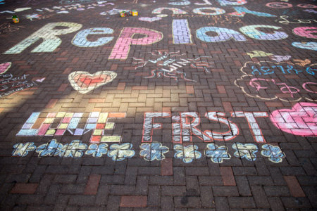 People from all parts of Grinnell contributed to the chalk art that now carpets 8th Ave. Photo by Garrett Wang. 