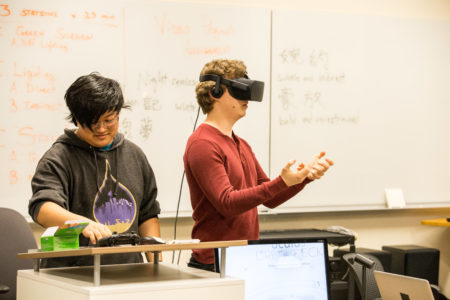 Co-founder and co-leader of Grinnell College Virtual Reality Club Richard Li '17 assists a student trying out the new virtual reality technology. Photo by Garrett Wang. 