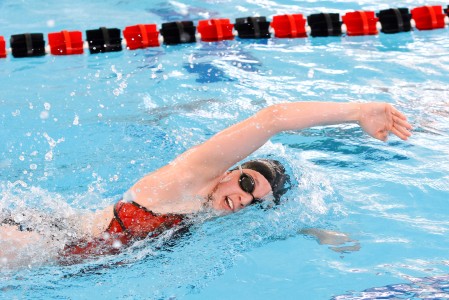 Callie Eyman Casey ’14  swims freestyle at Grinnell Invitational. Photo contributed by Rebecca Eyman.